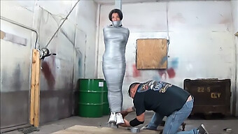 Voluptuous Woman Bound To A Pole With Duck Tape